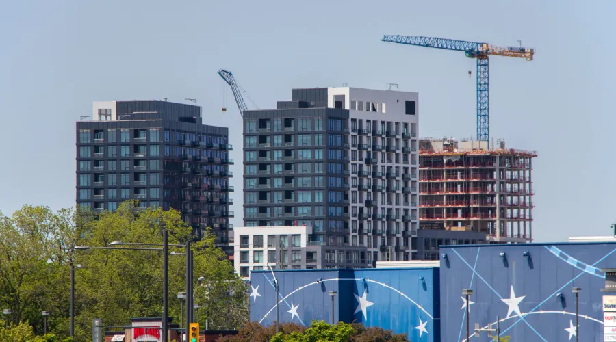 Stock image of a condo buildings and a crane working on a new construction.