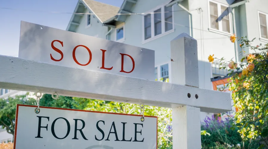 Stock photo of a for sale and sold sign in front of a house.