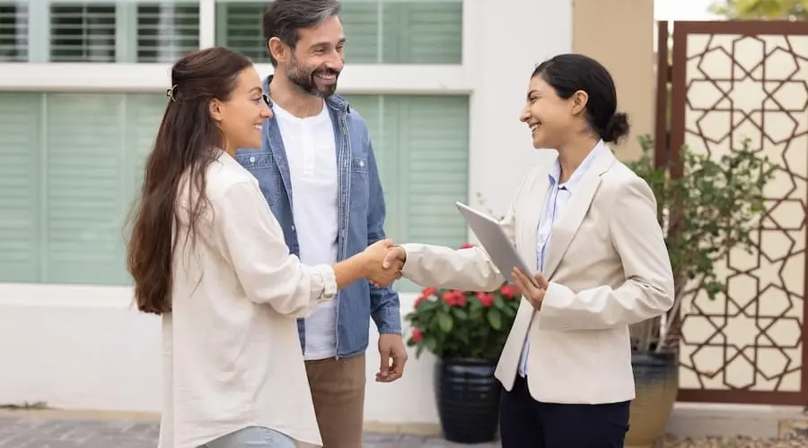 Stock photo - couple, agent and house.