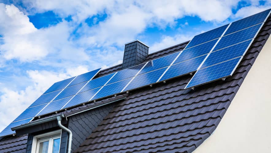 Stock image of a residential house roof with solar panels.